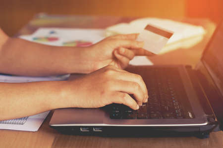 woman hand holding credit card and using laptop computer. Online shopping conceptの写真素材