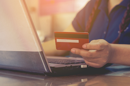 woman hand holding credit card and using laptop computer. Online shopping conceptの写真素材