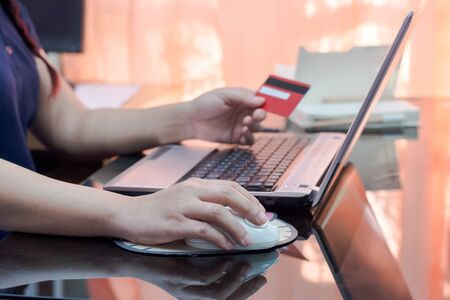 woman hand holding credit card and using laptop computer. Online shopping concept