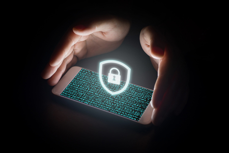 Cyber security network concept, man hand protection network with lock white icon and virtual screens on smartphone.の写真素材