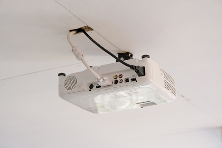 White projector hanging on the ceiling of conference room.の写真素材