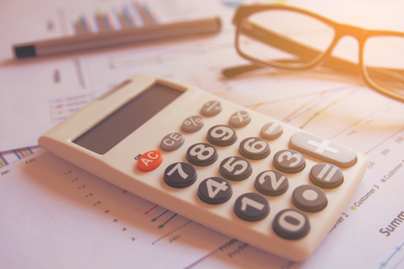 Office Concepts : data analyzing with calculator,glasses and pen. from charts and graph to find out...