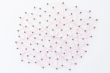 Linking entities, social media, Communications Network, The connection between the two networks. Network simulation on white paper linked together created by black nail and red threadの写真素材