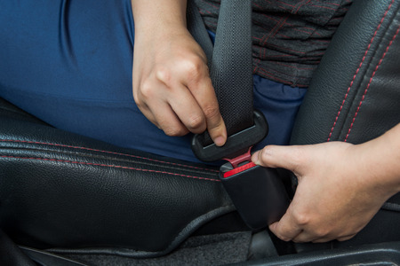 Car seat belt. woman fastens the seat belt on car Safe driving. Safety belt in hand.