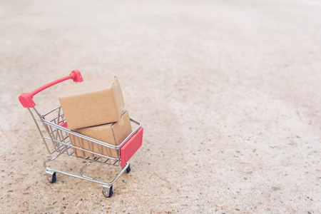 Shopping concept : Cartons or Paper boxes in shopping cart on concrete floor. online shopping consumers can shop from home and delivery service. with copy spaceの写真素材