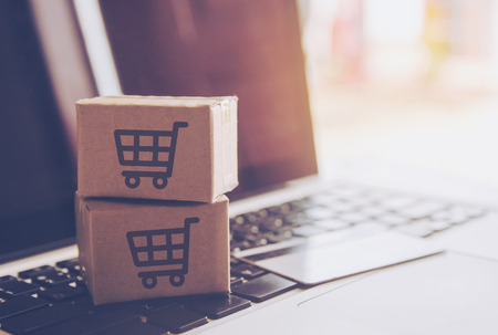 Shopping online concept - Shopping service on The online web. with payment by credit card and offers home delivery. parcel or Paper cartons with a shopping cart logo on a laptop keyboardの写真素材