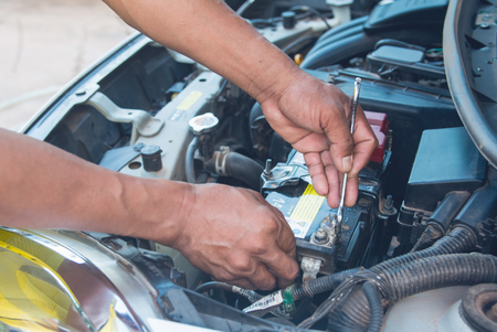 Car mechanic working Install battery with wrench in garage. Repair service.の写真素材