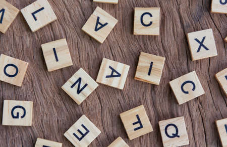 background of letterpress wood type printing blocks on wooden background, random letters of alphabet and punctuation stained by black inksの写真素材