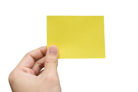Hand holding yellow paper isolated on white with clipping pathの写真素材