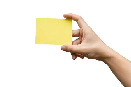Hand holding yellow paper isolated on white with clipping pathの写真素材