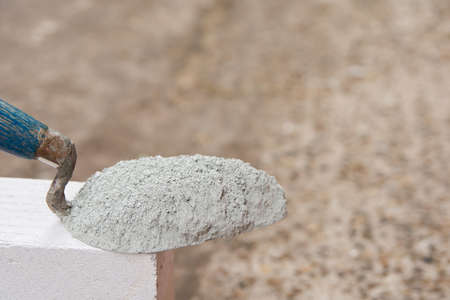 Cement powder or mortar with  trowel put on the Lightweight Concrete brick for construction work.の写真素材