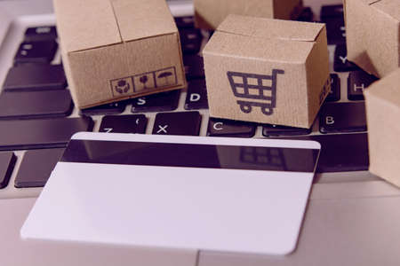 â¨Shopping online. Credit card and cardboard box with a shopping cart icon on laptop keyboard. Shopping service on The online web. offers home deliveryの写真素材