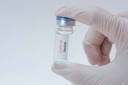 Vaccine COVID-19 (Coronavirus) glass bottle in medical doctor hand
