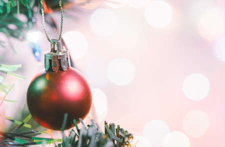 Christmas decoration. Red balls hanging on pine branches christmas tree garland and ornaments over abstract bokeh background with copy spaceの写真素材