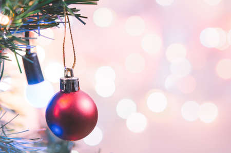 Christmas decoration. Red balls hanging on pine branches christmas tree garland and ornaments over abstract bokeh background with copy spaceの写真素材
