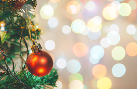 Christmas decoration. Red balls hanging on pine branches Christmas tree garland and ornaments over abstract bokeh background with copy spaceの写真素材