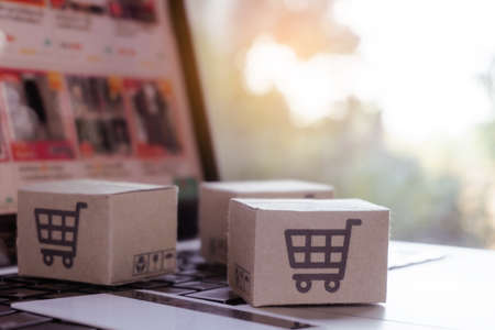 Online shopping. Credit card and cardboard box with a shopping cart  on laptop keyboard. Shopping...