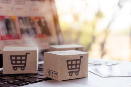 Online shopping. Credit card and cardboard box with a shopping cart  on laptop keyboard. Shopping...