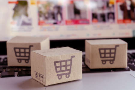 Online shopping. Cardboard box with a shopping cart   on laptop keyboard. Shopping service on The online web. offers home deliveryの写真素材