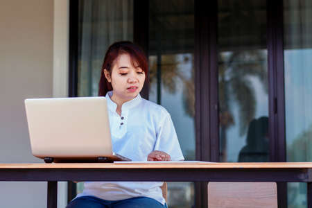 Asian woman working laptop. A woman working on a laptop at homeの写真素材