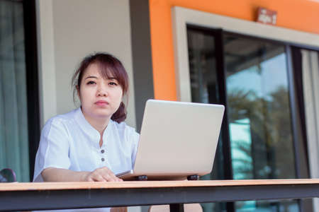 Asian woman working laptop. A woman working on a laptop at homeの写真素材
