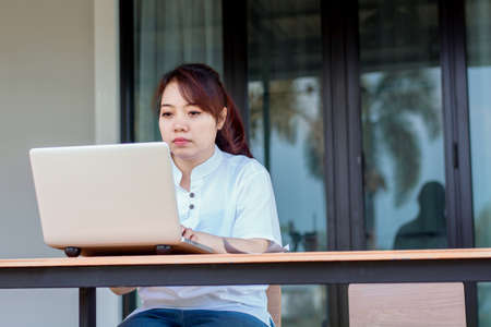Asian woman working laptop. A woman working on a laptop at homeの写真素材