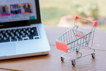 Shopping online concept - Empty shopping cart or trolley on a laptop keyboard.