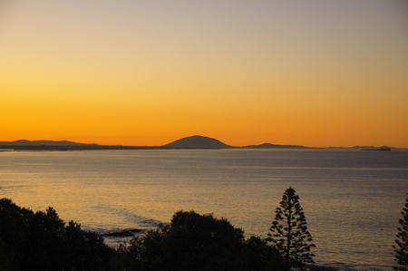 wonderful sunset over the ocean with treesの写真素材