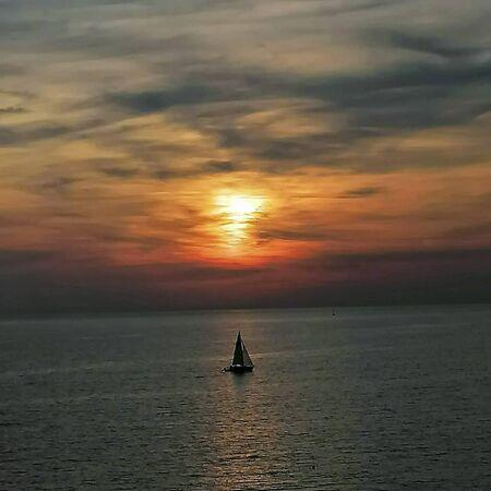 a boat in the ocean in the sunset at summer