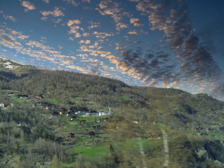 Mountain landscape in the Swiss Alps at sunset, view from the train windowの写真素材