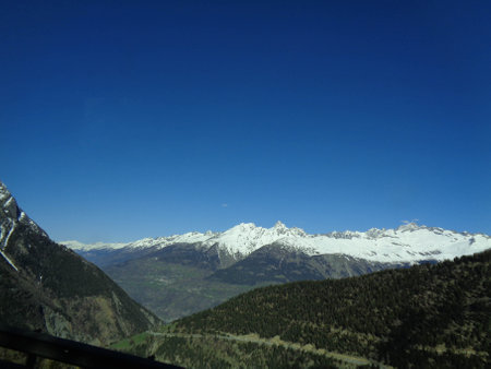 Mountain landscape with snow-capped peaks and blue sky.の写真素材