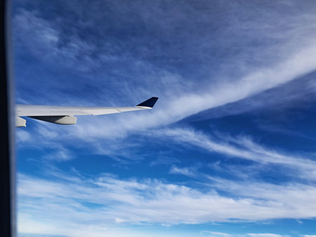 Airplane wing in the blue sky with white clouds. Travel conceptの写真素材