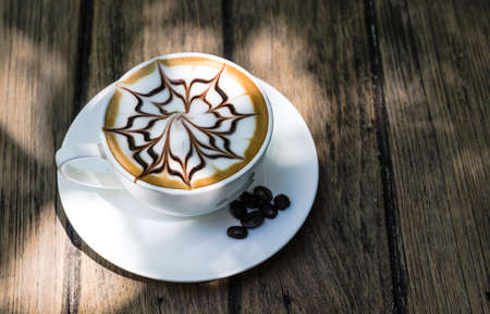 Cup of latte coffee on the wooden deskの写真素材