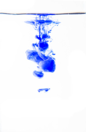 Blue Watercolor drops into the water on a white background.の写真素材
