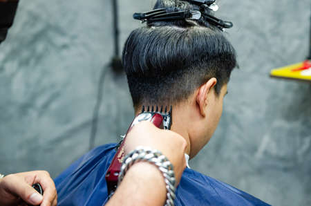 Hairdresser cutting a client's hair soft focus image.