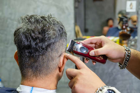 Hairdresser cutting a client's hair soft focus image.
