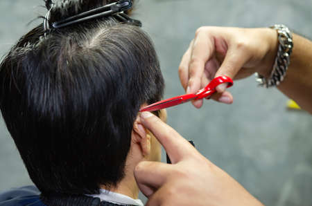 Hairdresser cutting a client's hair soft focus image.