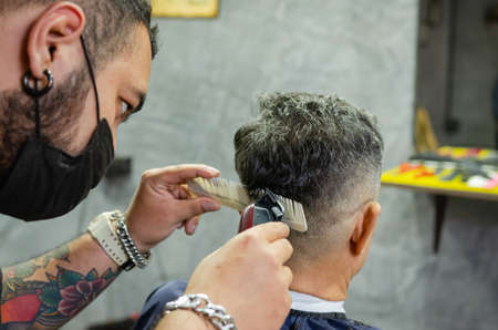 Hairdresser cutting a client's hair soft focus image.