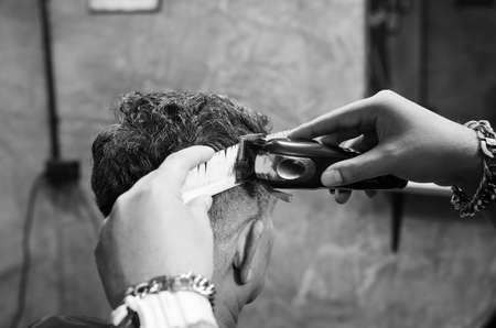 Hairdresser cutting a client's hair soft focus image.の写真素材