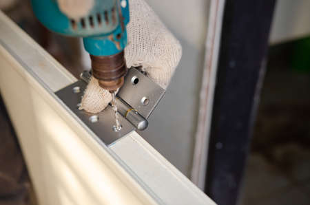 Construction worker installing a bathroom doorの写真素材