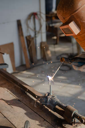young man doing hobbies welding steel in his workshop Soft focusの写真素材