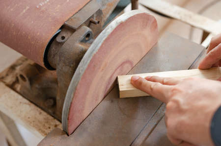 A young man who is working on wood crafts as a hobby.