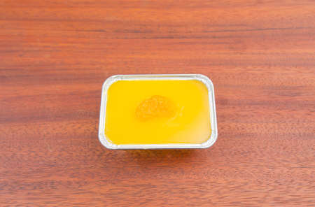 Orange cake decorated with fresh oranges on a wooden table.