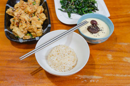 Simple vegetarian dish with eggs, tofu and sauteed vegetables.の写真素材