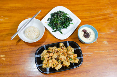 Simple vegetarian dish with eggs, tofu and sauteed vegetables.の写真素材