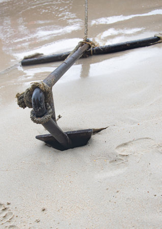 An anchor is planted on the sandy beach.の写真素材