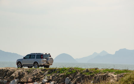 SUV parked by the sea on a sunny dayの写真素材
