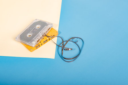 Audio cassette on a pastel-colored paper background. Retro media technology 80s. Music, entertainment. Top view. minimalism trendの写真素材