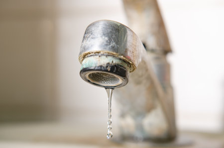 Drops of water from the old faucet.の写真素材