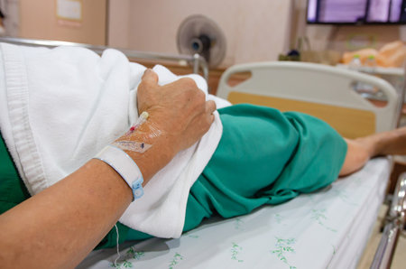 selective focus of patient wrist band tag who lay in white patient bedの写真素材